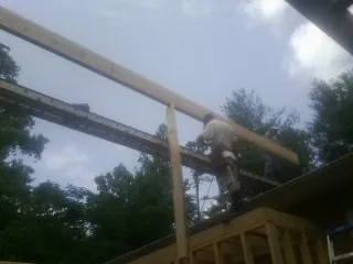 Carpenter setting a ridge beam over a new addition frame — Ice Dam Removal by Roofing Brothers in Ridgefield